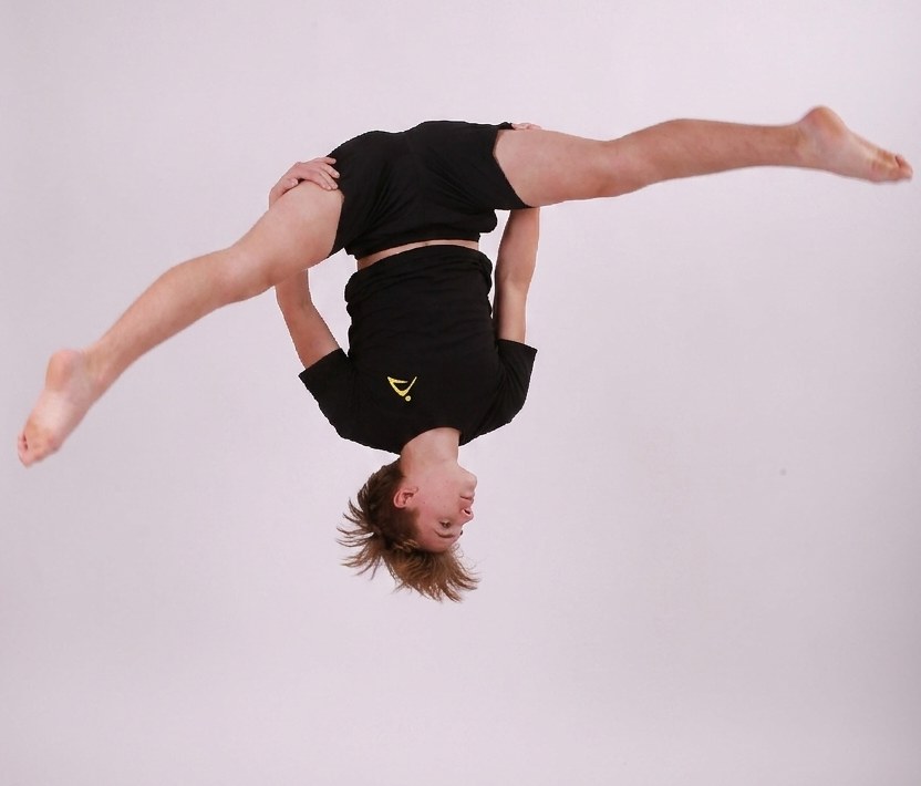 An Acrotrix student mid-air in a side somersault