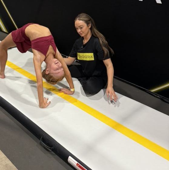 A coach spotting a student on an air track