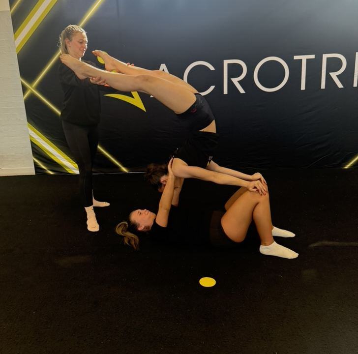 An Acrotrix coach supporting a student through a skill