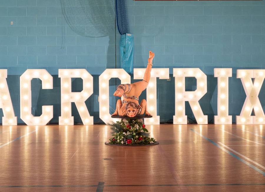 An Acrotrix student performing under the Acrotrix letters